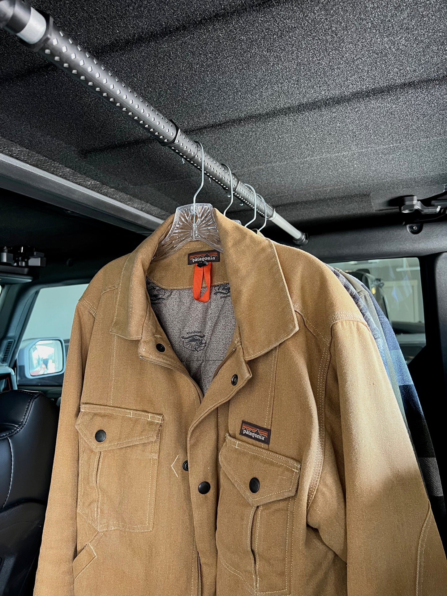Garment rod displayed with clothes hanging from hooks in Ford Bronco