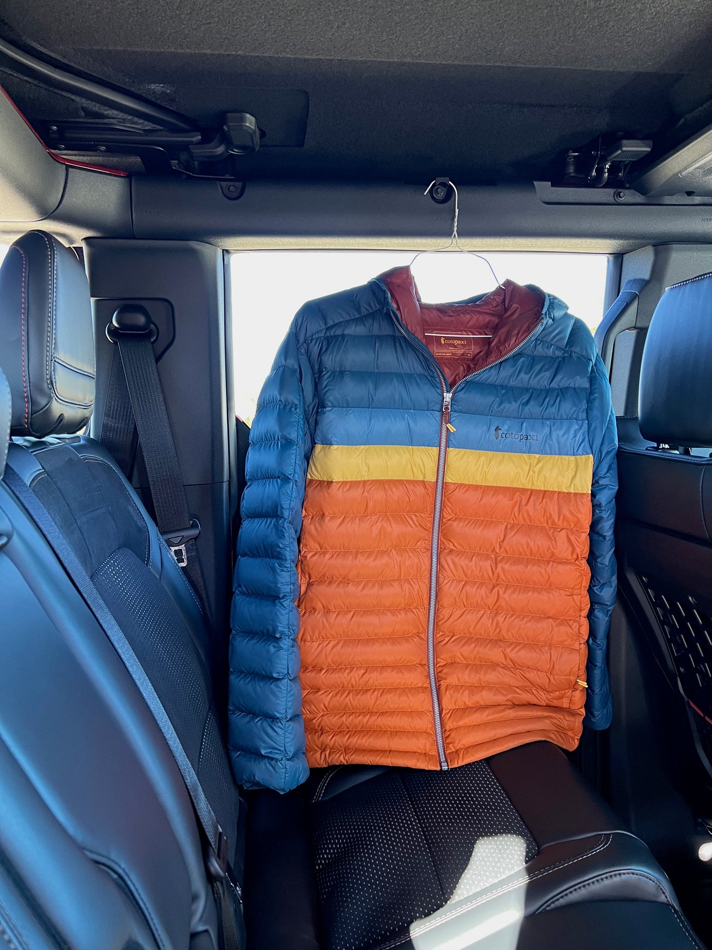 Jacket hanging from back of Ford Bronco with garment hook