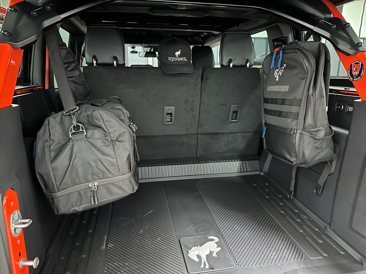 Gym and work bags hanging from Ford Bronco gear hooks